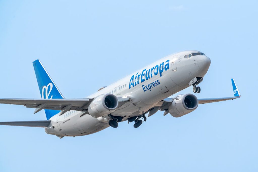 Air Europa Express Boeing 737-800 taking off against a clear blue sky.