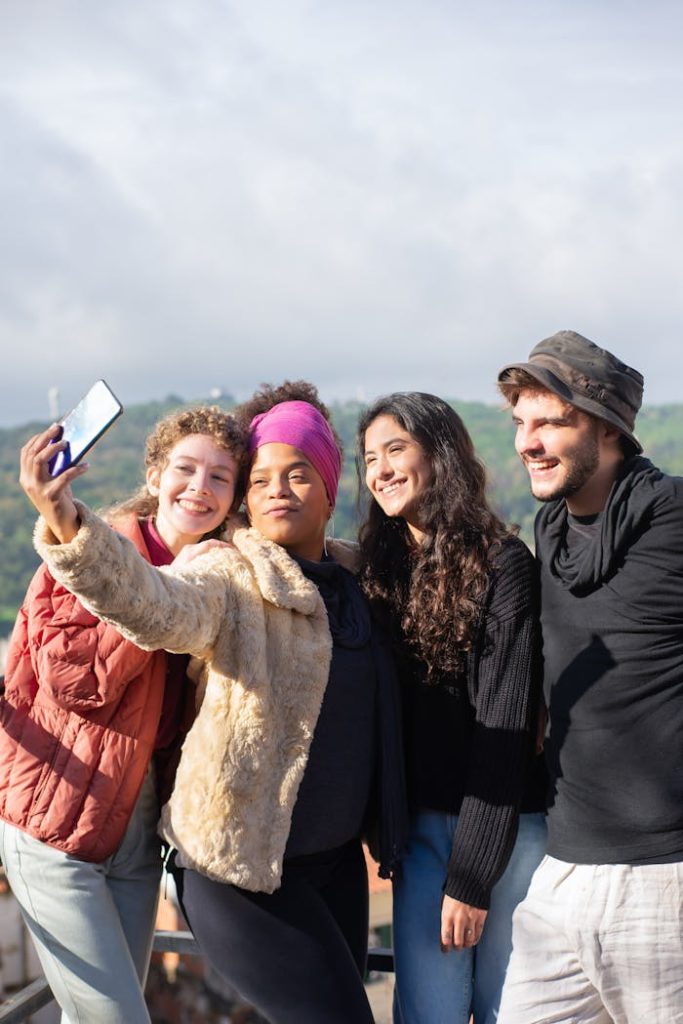 Joyful group of friends capturing a selfie outdoors in a picturesque location. Smiling and embracing friendship.
