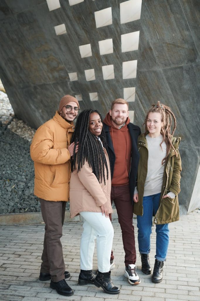 A group of friends smiling and posing outdoors, showcasing winter fashion and diverse togetherness.